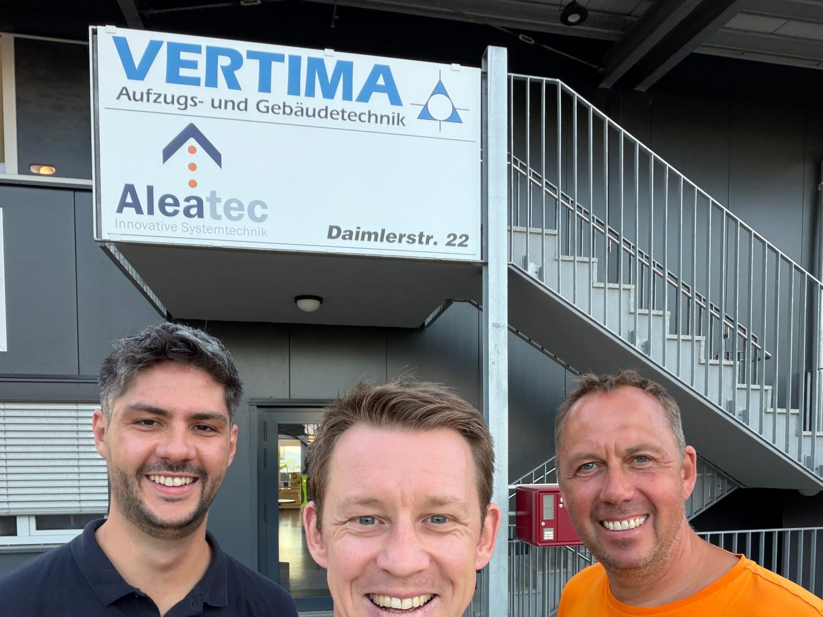 Mats Heidler und Timo Reum von Handwerk Digital mit Markus Stucke von der Vertima GmbH vor dem Firmenschild
